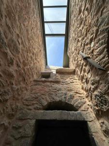 an opening in a stone wall with a window at Armathia Accommodation in Mestá