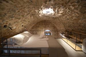 a bedroom with a bed in a stone wall at Armathia Accommodation in Mestá