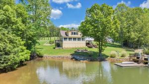a house sitting on the shore of a lake at Cape Cottage - Private dock & Fire Pit in Moneta