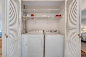 a small kitchen with white appliances and white cabinets at Lake Vibes - Pet Friendly Lakefront Condo! in Moneta +29 photos