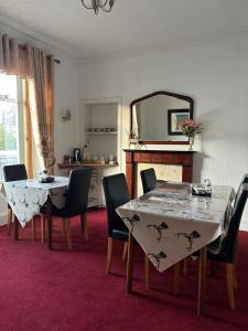 a dining room with a table and chairs and a mirror at Tay Villa in Inverness