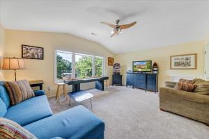 a living room with a blue couch and a piano at Cape Cottage - Private dock & Fire Pit in Moneta