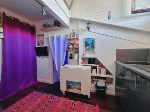 a room with purple and purple curtains and a sink at Studio côté Canal Hossegor in Hossegor