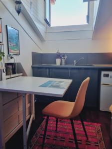 a kitchen with a table and a orange chair at Studio côté Canal Hossegor in Hossegor