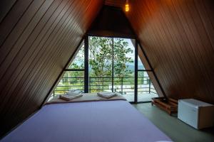 a bed in a room with a large window at Green Infinity Resort in Diyatalawa