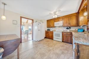 a kitchen with wooden cabinets and a white refrigerator at Pine Knob Point - Lakehouse w/ Private Dock in Moneta +28 photos