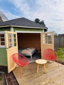 a small house with a bed and two chairs at The Bee Garden - Cosy Cabin in Lede