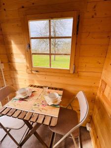 a table and chairs in a cabin with a window at The Bee Garden - Cosy Cabin in Lede