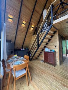 a dining room with a table and a staircase at Alpina Village, Jacuzzi Climatizado, Montaña, Fogata, Jarabacoa in Jarabacoa