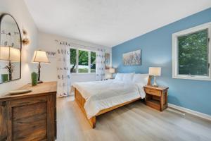 a blue bedroom with a bed and two windows at Sundance - Lakefront w/ Private Dock in Moneta