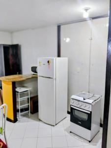a kitchen with a white refrigerator and a stove at Flat Bonito e Confortável in Campos dos Goytacazes