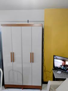 a large white cabinet with a tv in a room at Flat Bonito e Confortável in Campos dos Goytacazes +3 photos