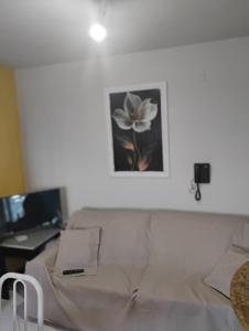 a room with a couch and a desk with a picture on the wall at Flat Bonito e Confortável in Campos dos Goytacazes