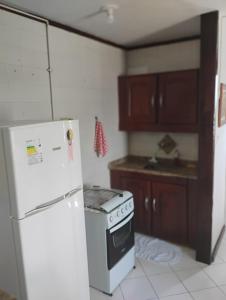 a kitchen with a white stove and a refrigerator at Flat Bonito e Confortável in Campos dos Goytacazes