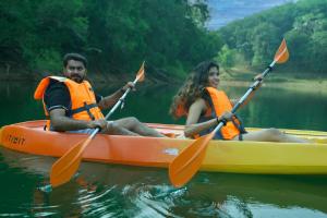 a man and a woman in a kayak in the water at Serene Aqua Hills in Kozhikode +28 photos