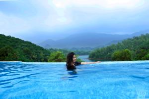 a woman standing in a pool in the water at Serene Aqua Hills in Kozhikode