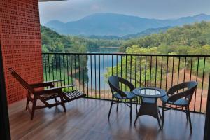 a balcony with a table and chairs and a view at Serene Aqua Hills in Kozhikode