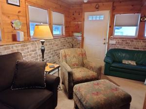 a living room with a couch and a chair at Chalet Cabin 7-Acres Pond! in Andover
