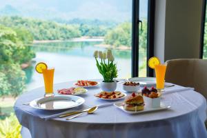 a table with food on it with a view of a lake at Serene Aqua Hills in Kozhikode