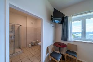 a bathroom with a shower and a red table and chairs at Ferienwohnungen Hebalm in Pack +65 photos