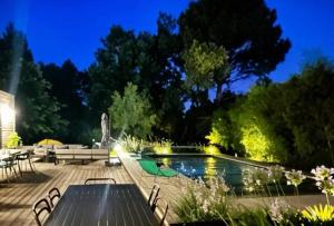 a patio with a table and a pool at night at Cap Ferret Villa Océane in Lège-Cap-Ferret