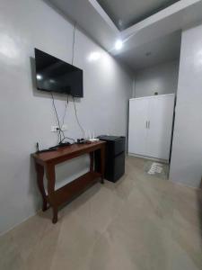 a room with a desk and a flat screen tv at T'zam Villa in Dipolog