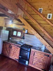 a kitchen with a stove top oven in a cabin at Cabaña El Guayabo in Villa Urquiza