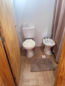 a bathroom with a toilet and a sink at Cabaña El Guayabo in Villa Urquiza +17 photos
