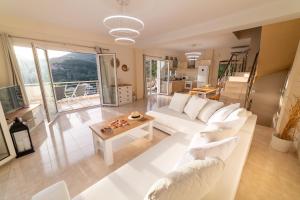 a living room with a white couch and a table at Villa Douros in Parga +22 photos