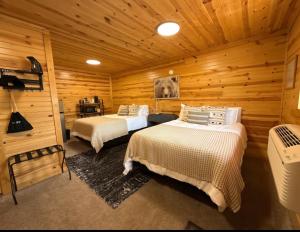 a bedroom with two beds in a log cabin at A Night In Northfield in Hixton +7 photos