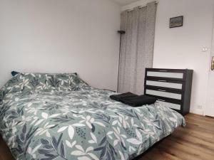 a bedroom with a bed with a green and white comforter at Maison 3 chambres Le Mans, proche circuit in Le Mans