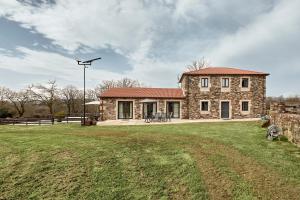 a stone house with a street light in front of it at Casa Do Gaiteiro in Melide