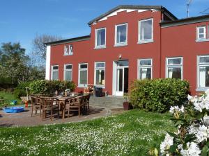 a red house with a table and chairs in front of it at Bauernhaus Premium in Fehmarn
