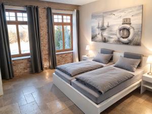 a bedroom with a bed with a painting on the wall at Bauernhaus Premium in Fehmarn