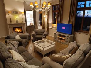 a living room with couches and a tv and a fireplace at Bauernhaus Premium in Fehmarn