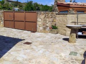 a patio with a stone wall and a stone table at Casa Candy in Muxia