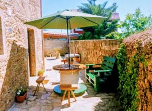 a patio with an umbrella and a table and chairs at Casa Candy in Muxia