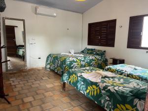 a room with two beds and a mirror at CASA DA PIPA in Pipa