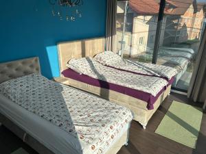 two beds sitting in a room with a window at Apartmen Emina in SJJ