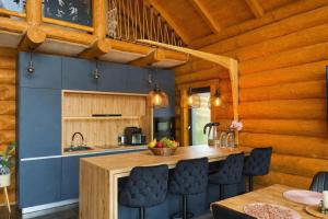 a kitchen with blue walls and a wooden ceiling at Căsuța Melimi cu piscină încălzită, ciubăr și saună in Râșca