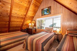 a bedroom with two beds in a log cabin at Das Berghaus By Hauserman Rentals in Tahoe City