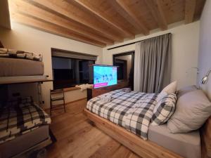 a bedroom with a bed and a flat screen tv at Green Hospitality Monolocale Stella Alpina in Livigno
