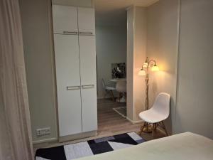 a bedroom with a white cabinet and a white chair at Easy Stay Mikkeli in Mikkeli +2 photos