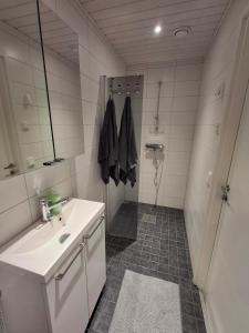 a white bathroom with a sink and a shower at Easy Stay Mikkeli in Mikkeli