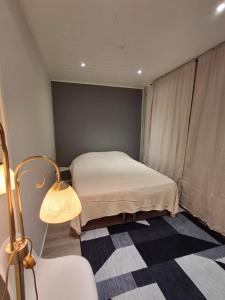 a small bedroom with a bed and a lamp at Easy Stay Mikkeli in Mikkeli