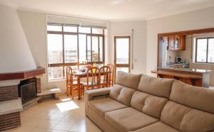 ein Wohnzimmer mit Sofa und Tisch und eine Küche in der Unterkunft Amorosa Beach Rooftop - 400 metros da Praia in Viana do Castelo