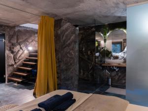a bedroom with a yellow curtain and a bathroom with a sink at Forest Whisper by GoldenPinpoint in Leštakovec