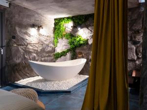 a bathroom with a bath tub with ivy on the wall at Forest Whisper by GoldenPinpoint in Leštakovec +27 photos