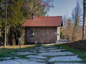 a stone path leading to a house with a red roof at Forest Whisper by GoldenPinpoint in Leštakovec