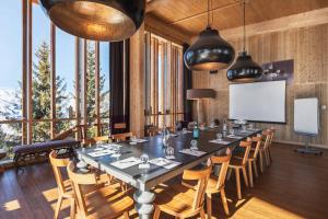 a conference room with a large table and chairs at L'Aiguille Grive Chalets Hotel in Arc 1800